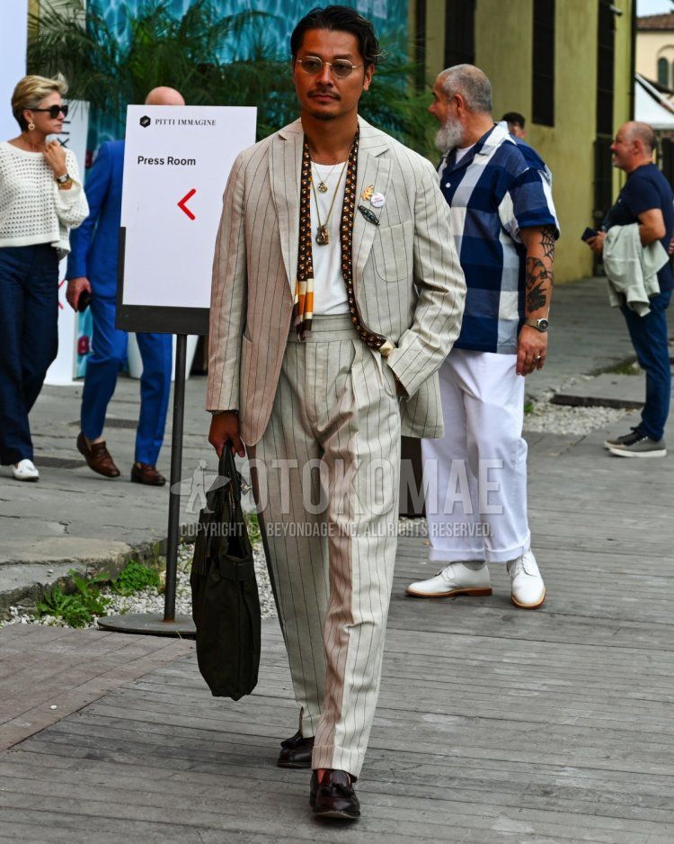 Men's spring, summer, and fall coordination and outfit with plain brown sunglasses, all-over black scarf, plain white T-shirt, black tassel loafer leather shoes, plain black tote bag, and gray striped suit.