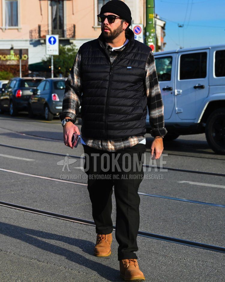 Men's fall/winter coordinate and outfit with plain black knit cap, black eyewear sunglasses, plain black inner down, black checked shirt, plain white t-shirt, plain black cargo pants, and brown work boots.