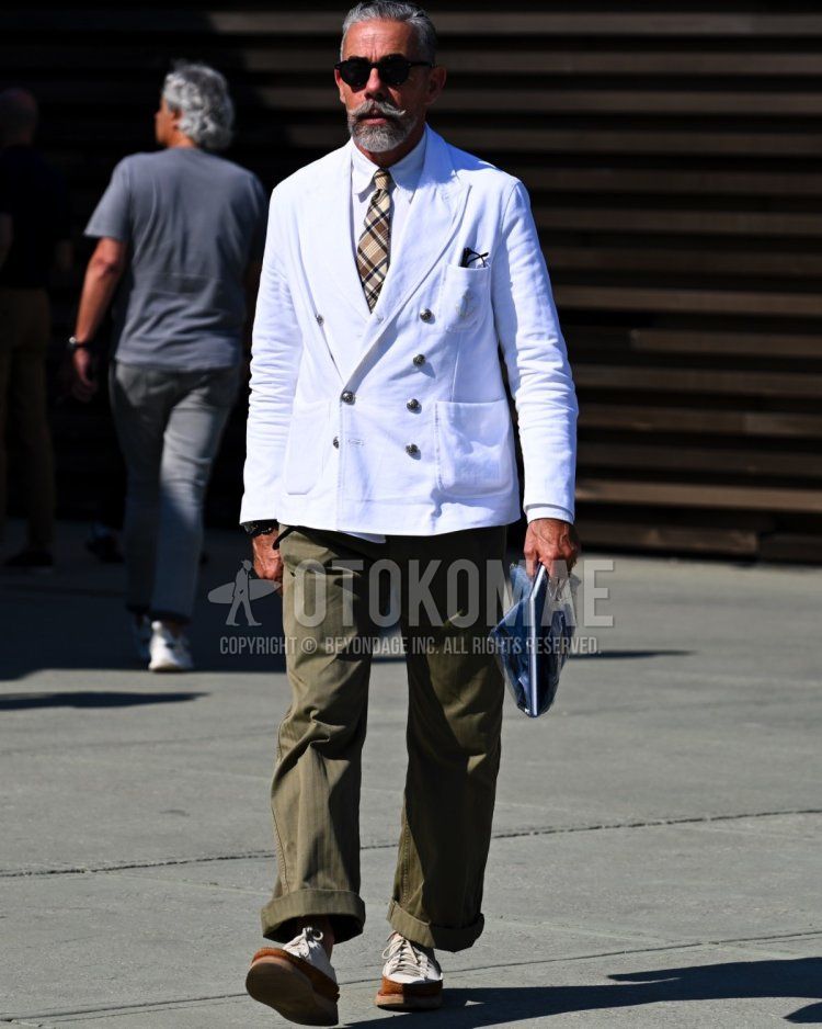 Men's spring, summer, and fall coordinate and outfit with plain black sunglasses, plain white tailored jacket, plain white shirt, plain olive green cotton pants, plain olive green chinos, and white low-cut sneakers.