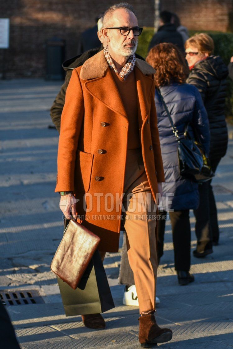 Boston plain black glasses, bandana/neckerchief with multi-colored stole, plain orange Ulster coat, plain orange sweater, plain beige slacks, plain beige cropped pants, brown/beige socks, brown boots, plain brown Clutch bag/second bag/drawstring bag for men's fall/winter outfits.