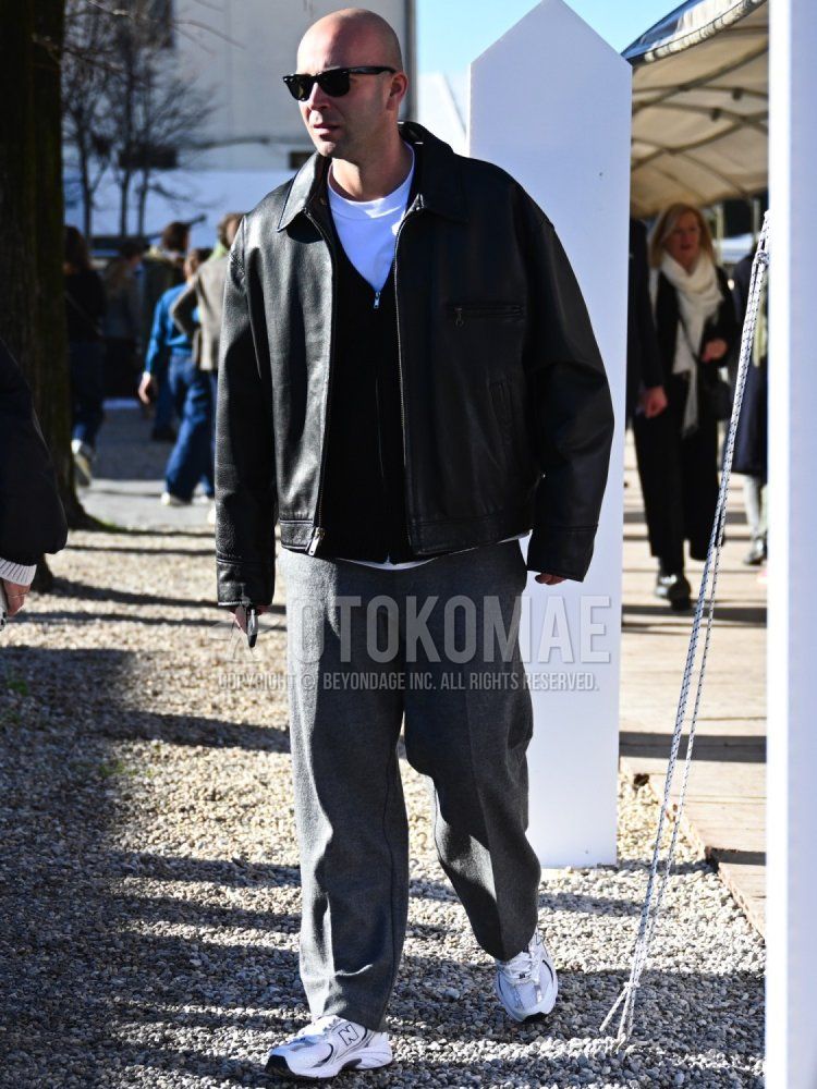 Men's fall/spring/winter outfit with plain green sunglasses, plain black leather jacket (not riders), plain white t-shirt, plain black cardigan, plain gray slacks, and white low-cut sneakers from New Balance.