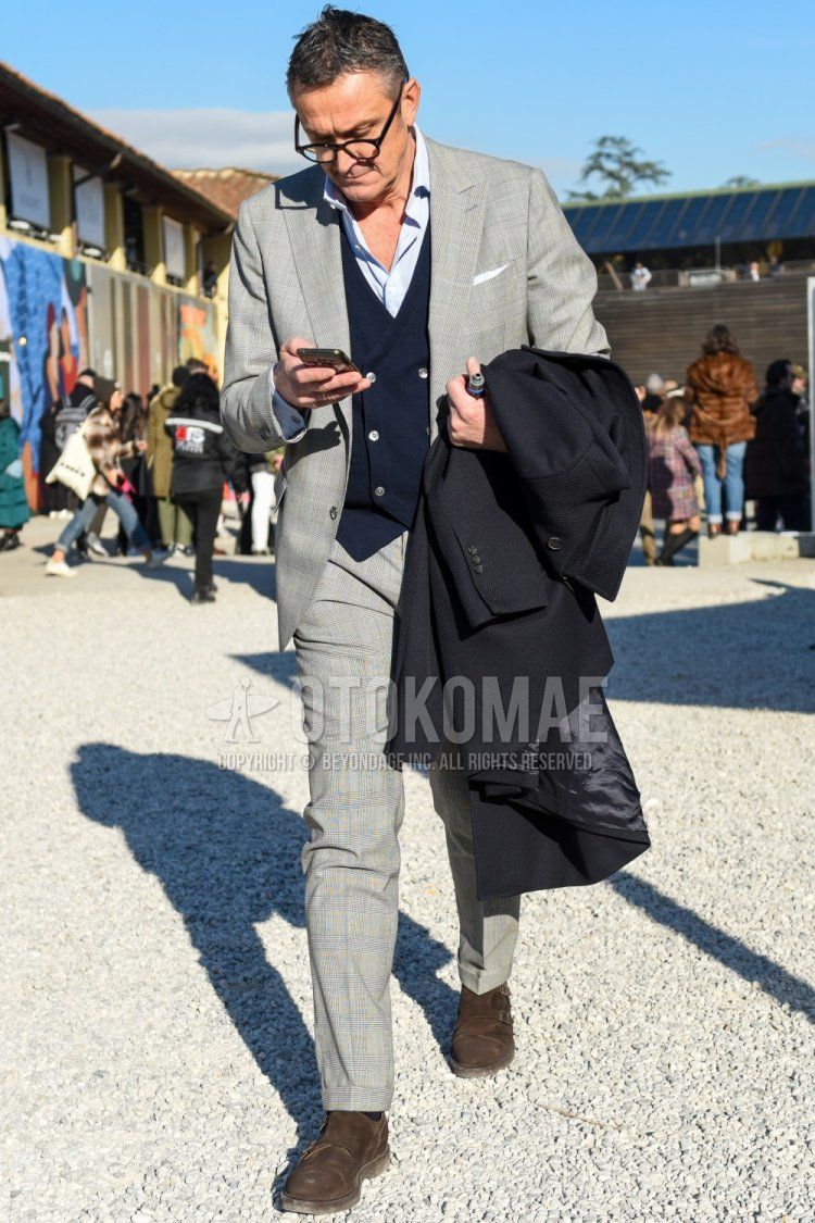 Men's fall/winter coordinate and outfit with plain black glasses, plain light blue shirt, plain navy gilet, brown monk shoes leather shoes, and gray checked suit.