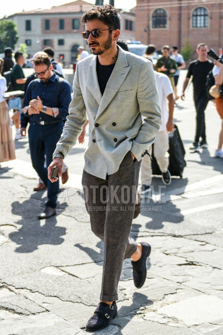 Men's spring, summer, and fall coordinate and outfit with brown tortoiseshell sunglasses, plain gray tailored jacket, plain black T-shirt, plain gray slacks, and black monk's leather shoes.