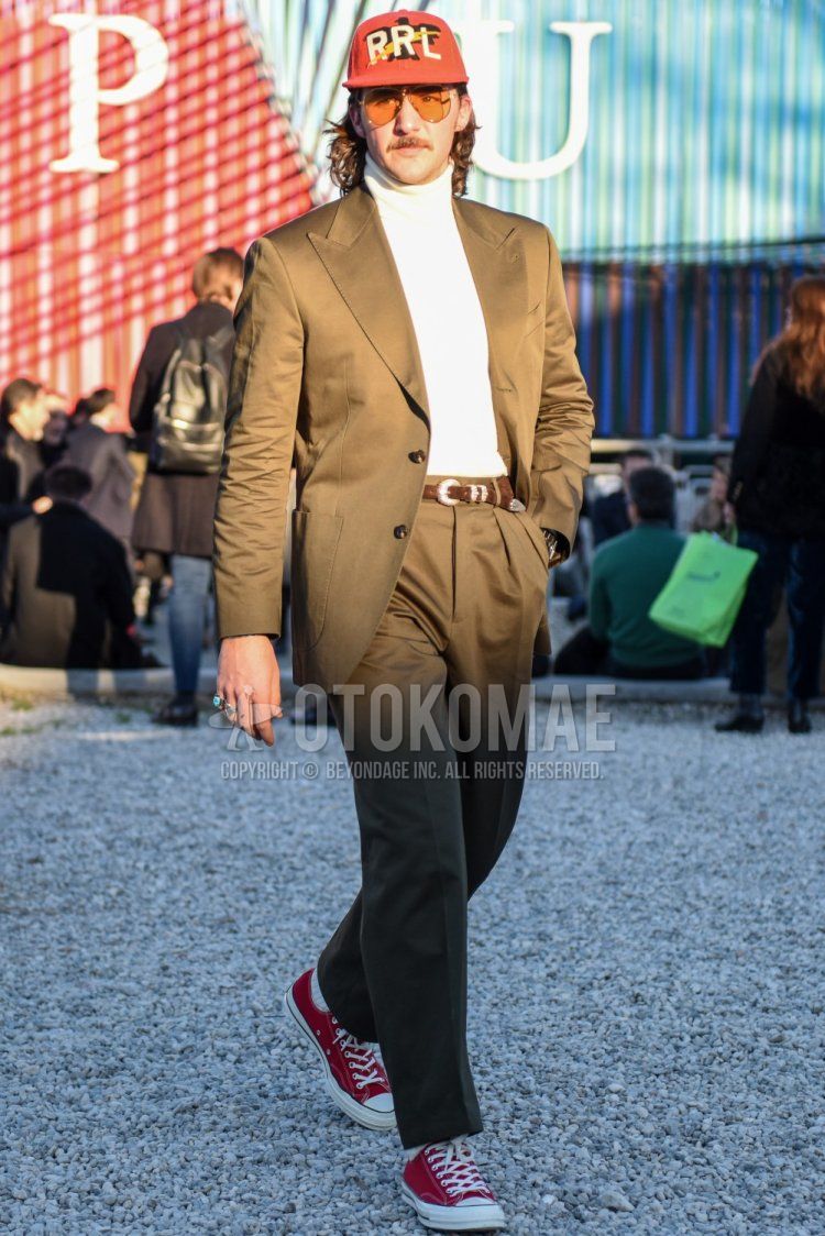 Ralph Lauren Double RL red lettered baseball cap, teardrop solid orange sunglasses, solid white turtleneck knit, solid brown leather belt, solid white socks, Converse Chuck Taylor red low cut sneakers, solid beige Men's spring and fall outfits and outfits with suits.