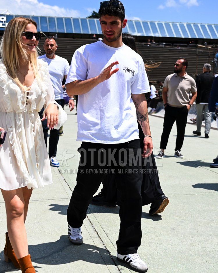 Summer/spring men's coordinate/outfit with plain black sunglasses, white one-pointed t-shirt, plain black denim/jeans, and white low-cut Adidas sneakers.