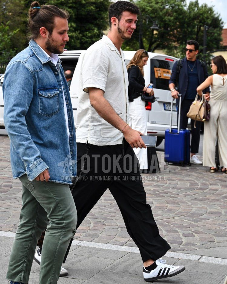 Summer/spring men's coordinate and outfit with plain white shirt, plain black wide-leg pants, plain black socks, and white low-cut Adidas sneakers.