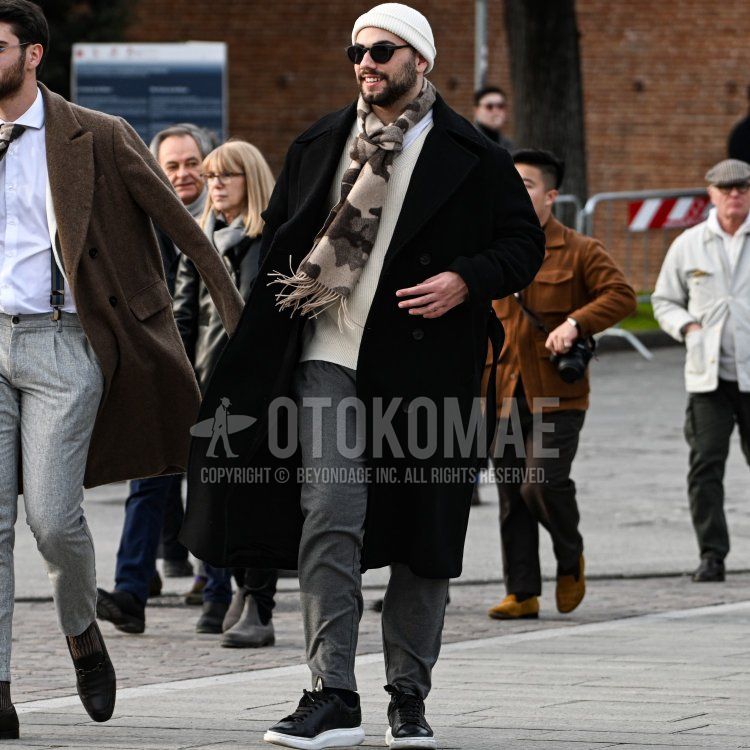 Men's fall/winter coordinate and outfit with plain white knit cap, plain black sunglasses, camouflage scarf/stall, plain black chester coat, plain white long T, plain white sweater, dark gray plain easy pants, plain black socks, and black low-cut sneakers.