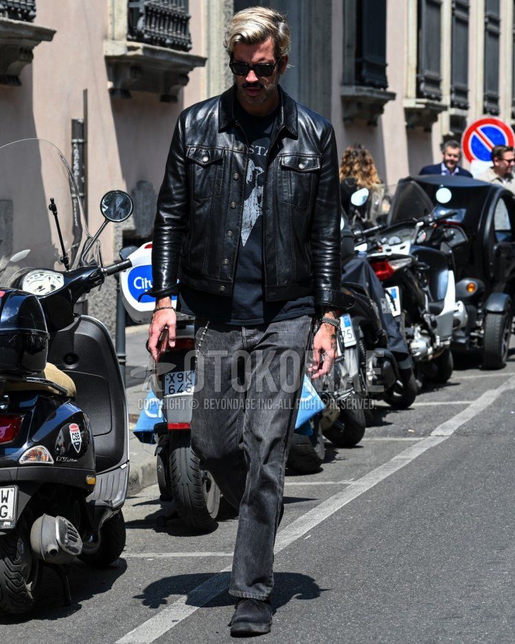 Men's spring/autumn coordinate and outfit with plain black sunglasses, plain black leather jacket (not rider's), black graphic t-shirt, plain black denim/jeans, and black low-cut sneakers.