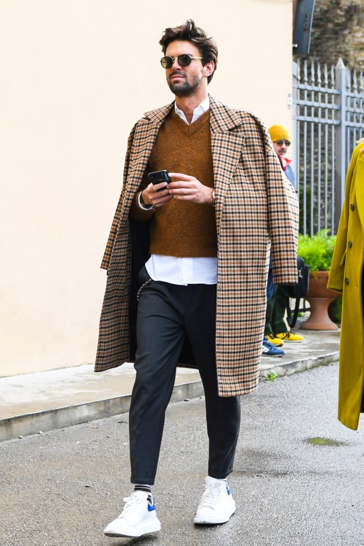 Alexander McQueen sneakers with a checked coat and brown vest
