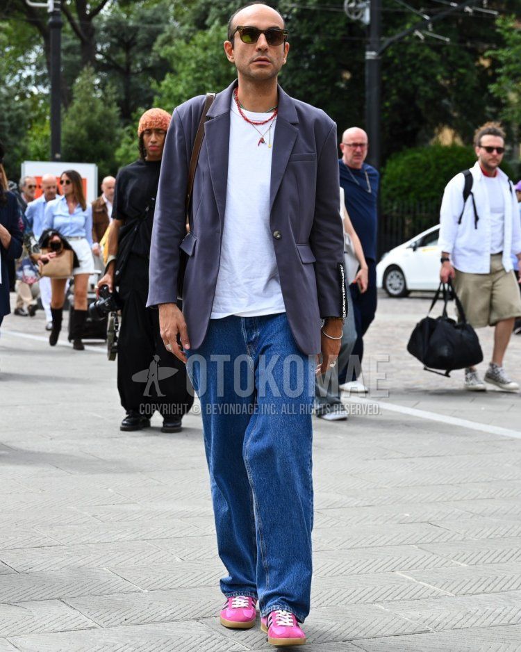 Men's fall/spring/summer coordinate and outfit with plain black sunglasses, plain dark gray tailored jacket, plain white t-shirt, plain blue denim/jeans, Adidas pink low-cut sneakers, and plain brown shoulder bag.