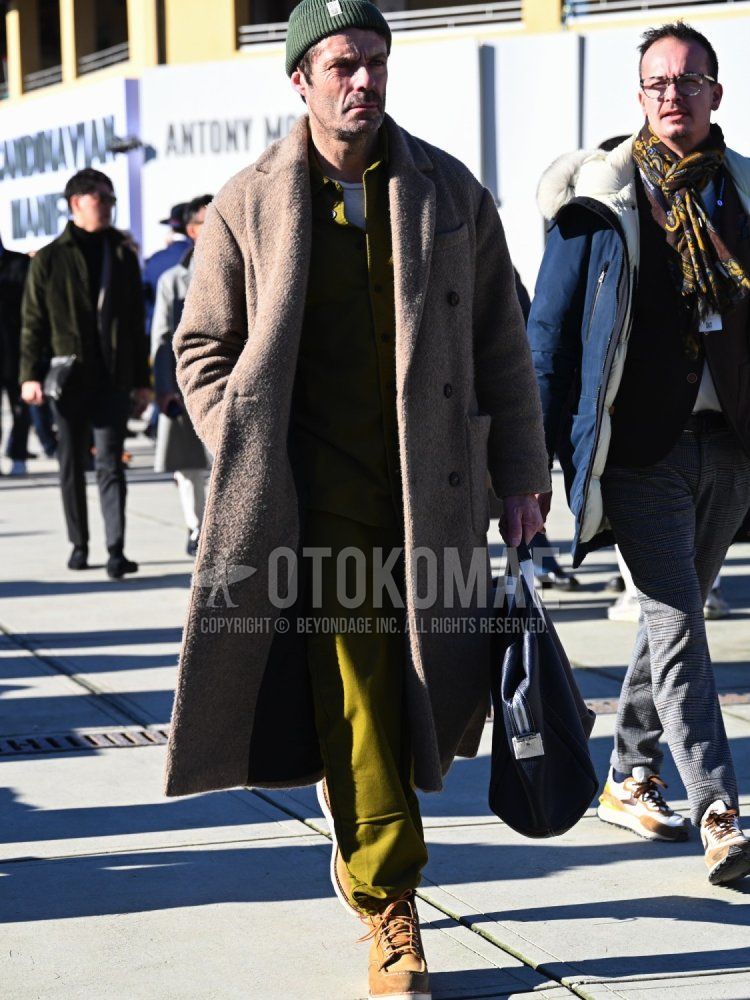 Men's winter/autumn coordinate and outfit with olive green solid knit cap, brown solid chester coat, white solid long T, green/yellow solid shirt, green/yellow solid sweatpants, beige work boots, and black solid Boston bag.
