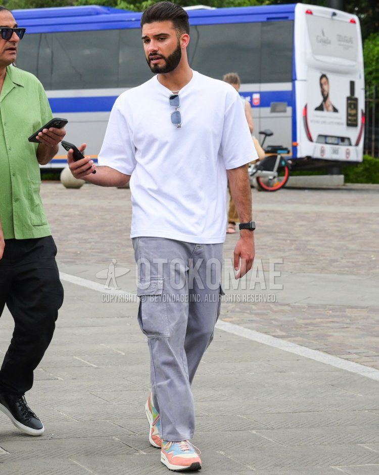 Men's summer coordinate with white T-shirt, light gray cargo pants, and light colored Nike Air Max 1