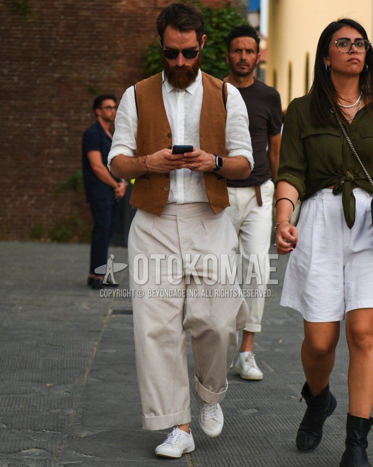 Men's spring/summer coordinate and outfit with plain black sunglasses, plain brown gilet, plain white shirt, plain beige cotton pants, plain beige wide-leg pants, and white low-cut sneakers.