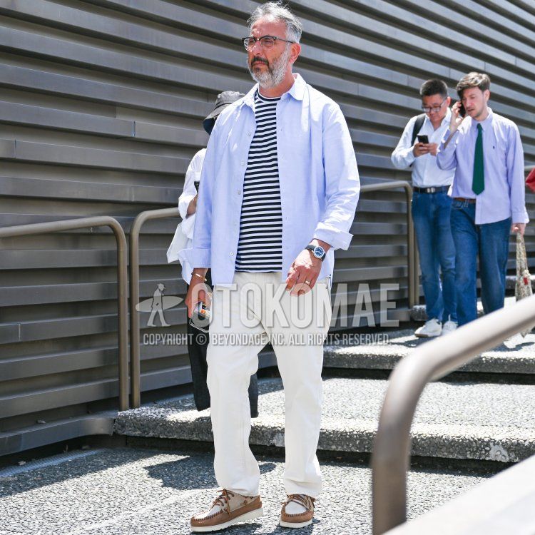 Men's fall/spring coordination and outfit with plain black/silver glasses, plain light blue shirt, plain navy/white t-shirt, plain white cotton pants, and white/brown moccasins/deck shoes leather shoes.