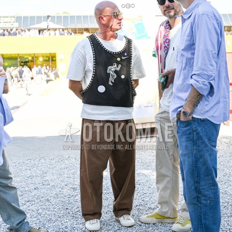 Men's spring/summer coordinate and outfit with clear plain sunglasses, plain white t-shirt, black top/inner gilet, plain brown wide-leg pants, and white sneakers.