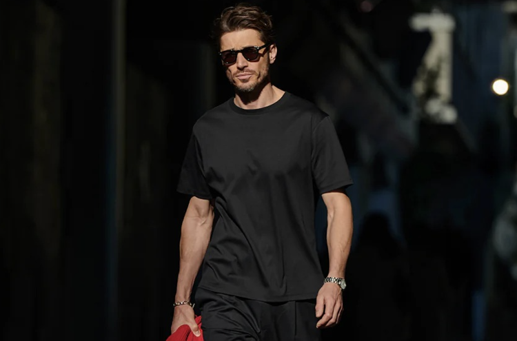 A handsome adult male dressed in a GENTLEMAN PROJECTS dress t-shirt "THE LEO" in black.