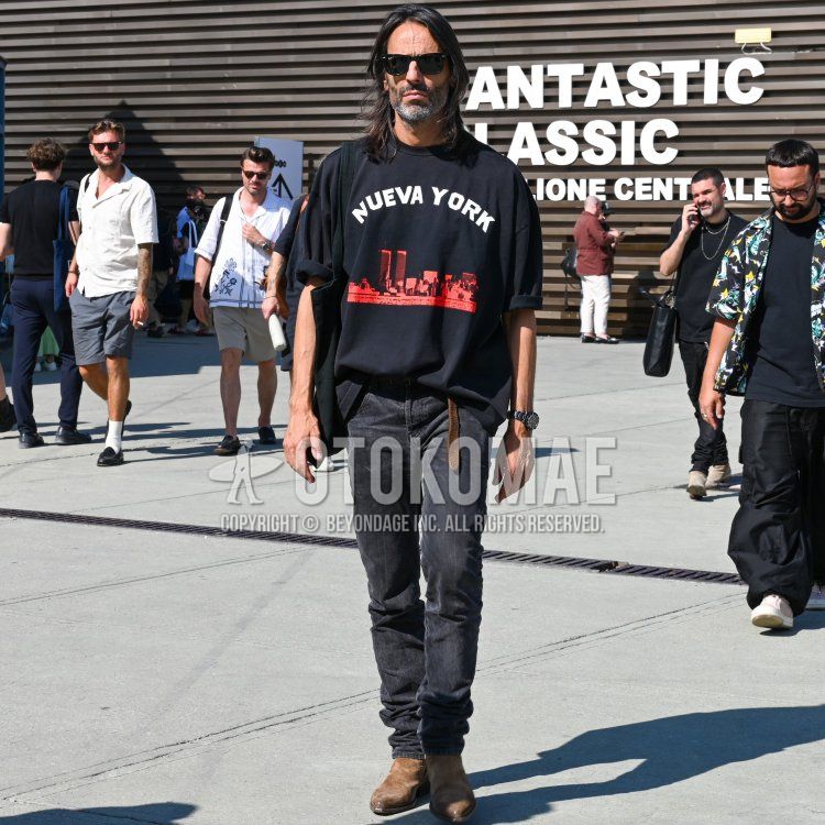 レイバン　ウェイファーラー　ウェリントンの黒無地のサングラス、黒レタードのTシャツ、ブラウン無地のレザーベルト、黒無地のデニム/ジーンズ、ブラウンのブーツ、黒無地のトートバッグを合わせた春夏のメンズコーデ・着こなし。