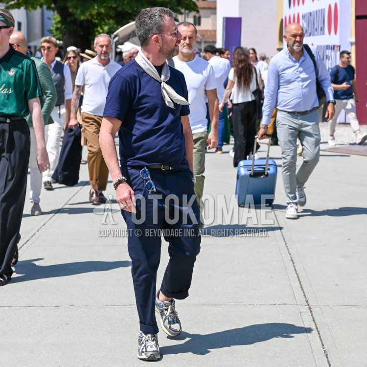 Summer/spring men's coordinate and outfit with clear plain sunglasses, white stole bandana/neckerchief, plain navy t-shirt, plain black leather belt, plain navy slacks, plain navy pleated pants, and white low-cut New Balance sneakers.