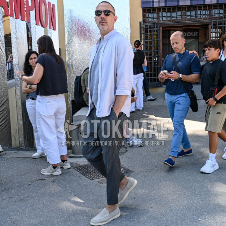 Summer/spring men's coordinate and outfit with Boston solid black sunglasses, stand collar solid purple shirt, solid gray t-shirt, gray striped slacks, gray striped ankle pants, gray loafer leather shoes, and gray suede shoes leather shoes.