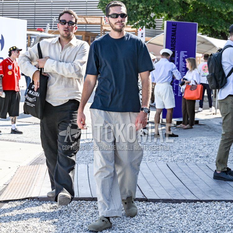 Men's spring/summer coordinate and outfit with plain black sunglasses, plain navy t-shirt, white striped slacks, white striped pleated pants, plain black socks, and Birkenstock Boston gray leather sandals.