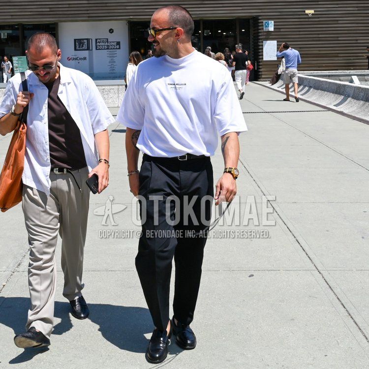 Summer/spring men's coordinate and outfit with brown tortoiseshell glasses, light blue lettered t-shirt, plain black leather belt, plain black slacks, plain black ankle pants, and black coin loafer leather shoes.