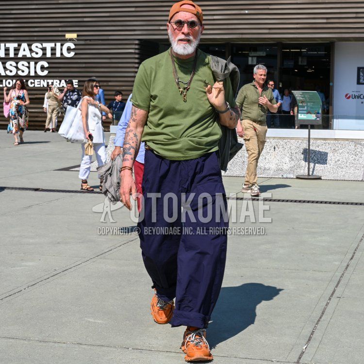 Men's spring/summer coordinate and outfit with solid orange baseball cap, solid gray sunglasses, solid gray outerwear, solid green t-shirt, solid navy cargo pants, and orange low-cut sneakers.