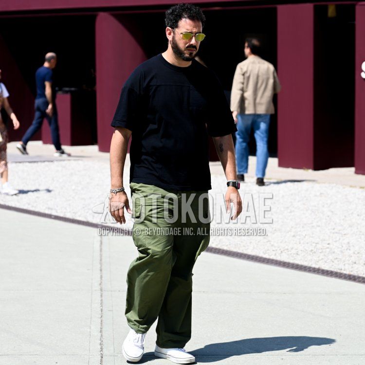 Summer/spring men's coordinate and outfit with gold solid sunglasses, solid black t-shirt, solid orange cargo pants, and white low-cut sneakers.