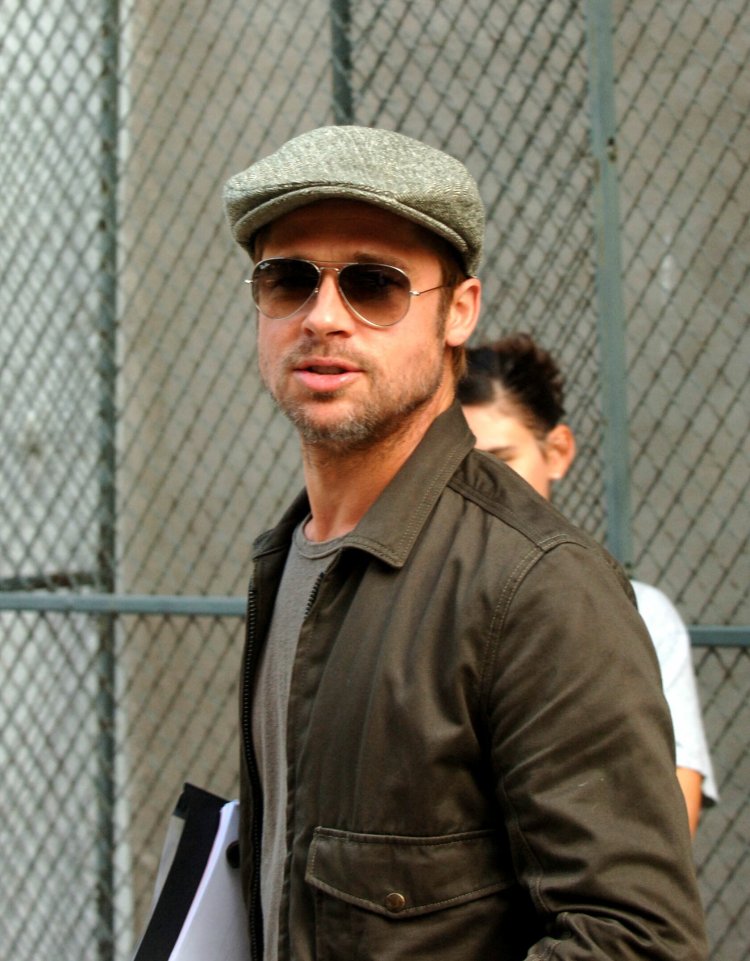 A scruffy faced Brad Pitt walks with scripts in his hands in NYC
