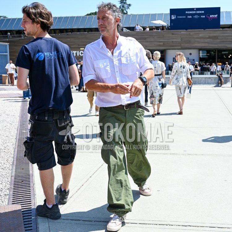 Men's spring/summer coordinate and outfit with plain white shirt, plain brown leather belt, plain green cargo pants, and white low-cut sneakers.