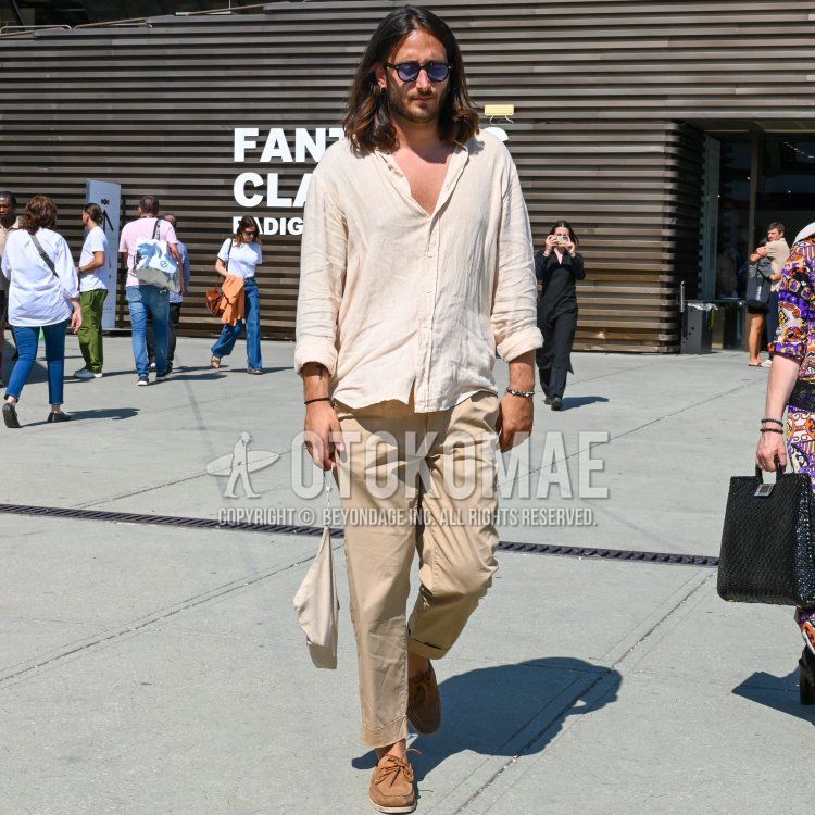 Summer/spring men's coordinate and outfit with Wellington plain black sunglasses, plain white shirt, plain beige chinos and brown moccasins/deck shoes leather shoes.