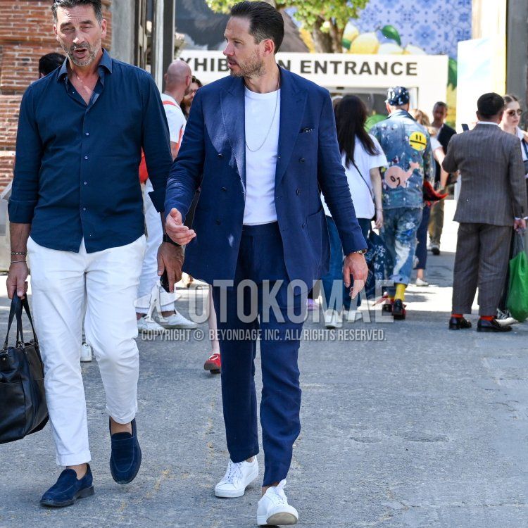 Men's fall/spring coordination and outfit with plain white t-shirt, white low-cut sneakers, and plain blue suit.