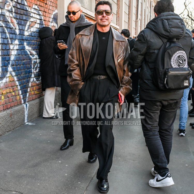 Men's winter coordinate and outfit with plain black sunglasses, plain brown rider's jacket, plain black sweater, plain black leather belt, black boots, and plain dark gray casual setup.