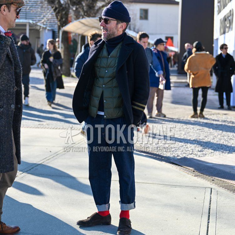 Men's spring/fall/winter outfit with solid navy knit cap, solid black sunglasses, solid navy p-coat, solid olive green inner down, solid navy turtleneck knit, solid navy denim/jeans, solid red socks, brown loafer leather shoes Outfit.