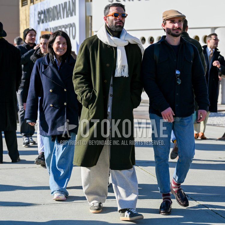 Men's fall/winter outfit with plain brown sunglasses from Boston, plain white scarf/stall, plain olive green stainless steel coat, plain gray sweatpants, and black low-cut sneakers.