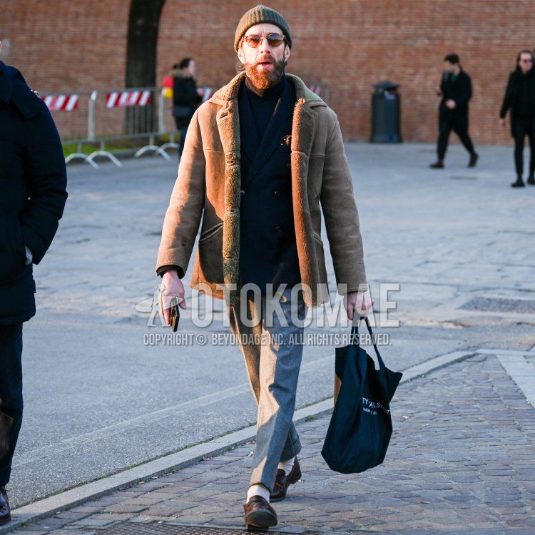 Dark gray solid knit cap, brown eyewear sunglasses, brown solid boa jacket/coat, brown solid leather coat, navy solid tailored jacket, navy solid turtleneck knit, gray solid slacks, white solid socks, brown coin loafer leather shoes, and a solid black tote bag, winter men's coordinate/outfit.