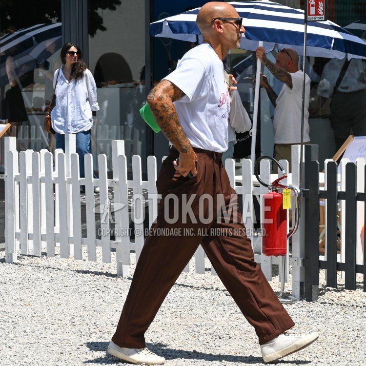 Summer/spring men's coordinate and outfit with plain black sunglasses, white lettered t-shirt, plain brown slacks, plain brown pleated pants, plain white socks, and white low-cut sneakers.
