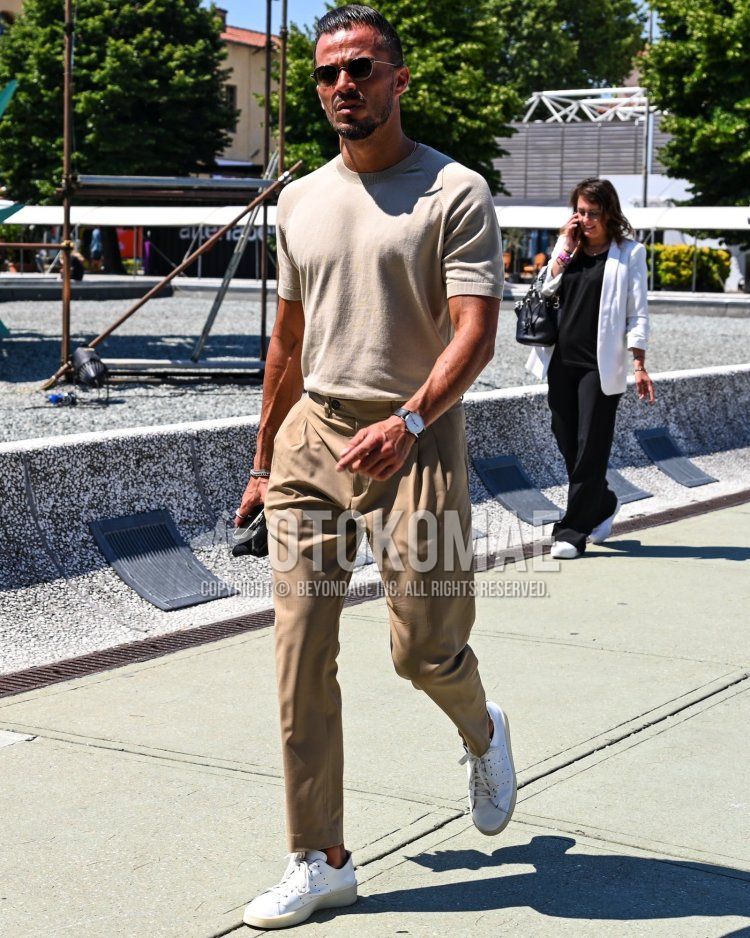 Summer/spring men's coordinate and outfit with plain beige t-shirt, plain beige beltless pants, and white low-cut sneakers.