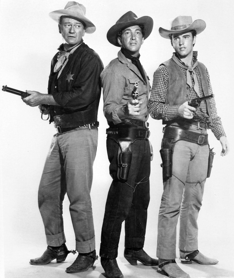 DEAN MARTIN, JOHN WAYNE and RICK NELSON (RICKY) in RIO BRAVO (1959), directed by HOWARD HAWKS. Copyright WARNER BROTHERS.