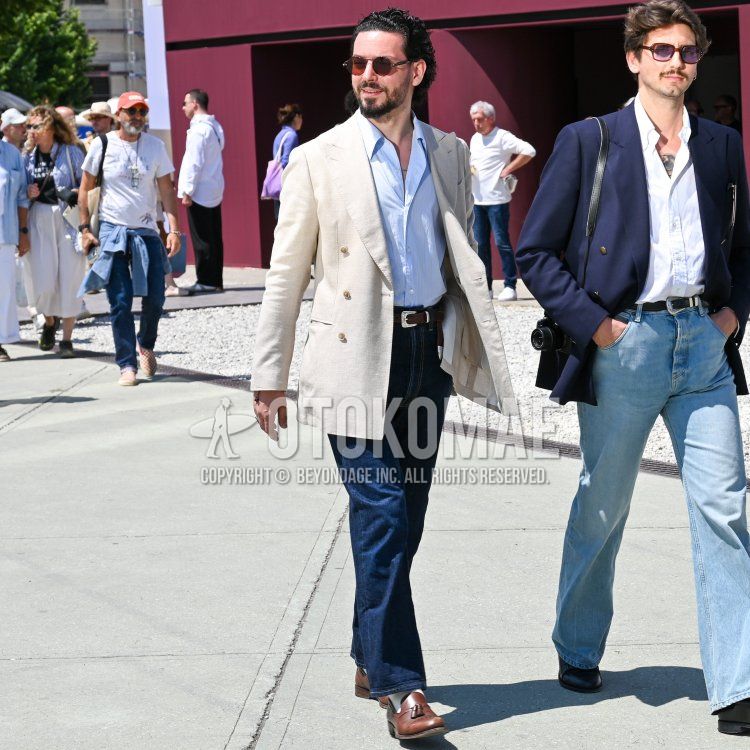 Men's spring/summer coordinate and outfit with plain black sunglasses, plain white tailored jacket, blue striped shirt, plain brown leather belt, plain blue denim/jeans, plain white socks, brown tassel loafer leather shoes.