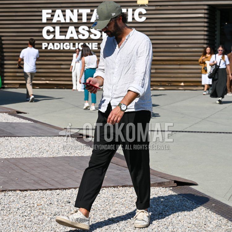 Summer/spring men's coordinate and outfit with New Era green lettered baseball cap, clear plain glasses, band collar plain white shirt, plain black slacks, plain black ankle pants, and white low-cut sneakers.