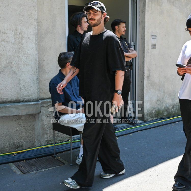 グレー無地のベースボールキャップ、黒無地のサングラス、黒無地のTシャツ、黒無地のスラックス、白・グレーローカットのスニーカーを合わせた春夏のメンズコーデ・着こなし。