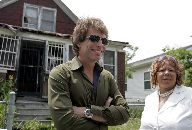 Musician Jon Bon Jovi tours an east side neighborhood with Linda Smith and Habitat for Humanity in Detroit